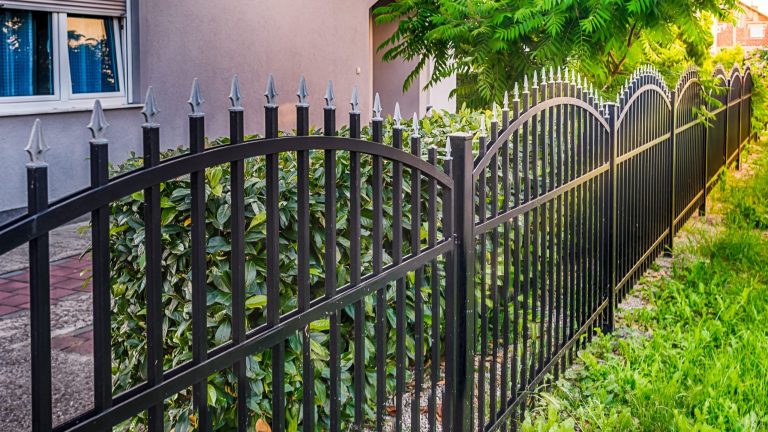 Black ornamental iron fence with arched sections and spear top pickets